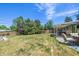 Expansive backyard featuring a lush lawn, mature trees, and covered patio area perfect for outdoor relaxation at 4855 E Atlantic Pl, Denver, CO 80222