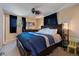 A Primary bedroom displays a king-size bed with a blue comforter, dark wood furniture, and bright windows at 4855 E Atlantic Pl, Denver, CO 80222