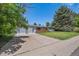 Home exterior features a spacious driveway, lush front lawn, and attractive landscaping at 4855 E Atlantic Pl, Denver, CO 80222