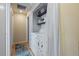 A laundry room with a washer and dryer behind a curtain, with overhead storage shelves at 4855 E Atlantic Pl, Denver, CO 80222