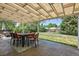 Covered patio with a stone floor, outdoor dining table, and views to a lush backyard at 4855 E Atlantic Pl, Denver, CO 80222