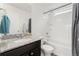 Bright bathroom featuring a granite vanity, shower-tub combo, and clean, white fixtures at 18552 E 54Th Ave, Denver, CO 80249