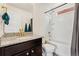 Bathroom features a granite countertop, vanity, and shower-tub combo with tiled walls at 18552 E 54Th Ave, Denver, CO 80249