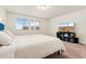 Bright bedroom features two sunny windows, neutral walls, and a modern entertainment center at 18552 E 54Th Ave, Denver, CO 80249