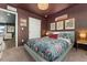 Serene bedroom with plush carpet, warm lighting, and a bed that is made with floral bedding and a maroon pillow at 18552 E 54Th Ave, Denver, CO 80249