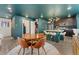 Open dining area with a round table, modern kitchen with island seating, and stylish lighting at 18552 E 54Th Ave, Denver, CO 80249