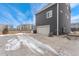 Rear of home, featuring an attached garage with a driveway with some snow at 18552 E 54Th Ave, Denver, CO 80249