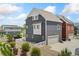 Modern two-story house showcasing gray siding, manicured landscaping, and a detached garage at 18552 E 54Th Ave, Denver, CO 80249