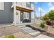 Inviting front porch with seating, a white door with a wreath, and lovely landscaping at 18552 E 54Th Ave, Denver, CO 80249