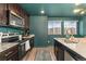 Kitchen featuring stainless steel appliances, granite countertops, and dark cabinets at 18552 E 54Th Ave, Denver, CO 80249