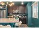 Kitchen featuring dark cabinetry, stainless steel appliances, and modern lighting at 18552 E 54Th Ave, Denver, CO 80249
