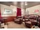 Finished basement with multiple leather couches, dark walls, red accents, and recessed lighting at 26781 E Clifton Dr, Aurora, CO 80016