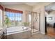 This bathroom features a tub with jets, a shower with glass doors and a nice view from the window at 26781 E Clifton Dr, Aurora, CO 80016
