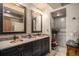 Double vanity bathroom featuring granite countertops, bronze faucets, and decorative mirrors at 26781 E Clifton Dr, Aurora, CO 80016