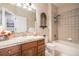 Neutral-toned bathroom with wood vanity, combination shower and tub, and decorative accents at 26781 E Clifton Dr, Aurora, CO 80016