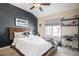 Cozy bedroom features a queen-sized bed, a dark accent wall, a ceiling fan, and a large window at 26781 E Clifton Dr, Aurora, CO 80016