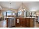 Open kitchen with granite countertops, stainless steel appliances, and a view to a vaulted-ceiling eating area at 26781 E Clifton Dr, Aurora, CO 80016