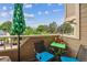 Private outdoor balcony furnished with a bistro set and offering serene views of surrounding greenery at 1818 S Quebec Way # 4, Denver, CO 80231