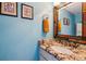Bright bathroom features granite countertop and unique mirror frame at 1818 S Quebec Way # 4, Denver, CO 80231