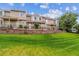 Inviting townhomes with manicured lawn, brick retaining wall, and black metal fencing at 1818 S Quebec Way # 4, Denver, CO 80231