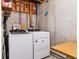 Basement laundry area featuring a white Whirlpool washer and dryer next to exposed ductwork and a wood table at 1818 S Quebec Way # 4, Denver, CO 80231