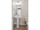 This powder room offers a pedestal sink, wood-look flooring and a neutral color palette at 22183 E Rocky Top Pl, Aurora, CO 80016