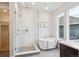 Luxurious bathroom featuring a glass-enclosed shower and soaking tub by a bright window at 22183 E Rocky Top Pl, Aurora, CO 80016