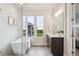 Bright bathroom featuring a freestanding tub, glass shower, and dual windows with a scenic backyard view at 22183 E Rocky Top Pl, Aurora, CO 80016