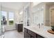 Bright bathroom featuring dual vanities, large mirrors, and a view into the main bedroom at 22183 E Rocky Top Pl, Aurora, CO 80016