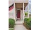 Charming front entrance with a red door, partial porch, and neatly trimmed green shrubs at 8371 S Upham Way # 103, Littleton, CO 80128