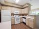 Well-lit kitchen featuring white appliances, light wood cabinetry and laminate countertops at 8371 S Upham Way # 103, Littleton, CO 80128