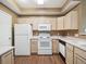 Bright kitchen with white appliances, light wood cabinets, and a modern electric range at 8371 S Upham Way # 103, Littleton, CO 80128