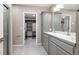 Stylish bathroom with double sinks, gray cabinetry, and convenient access to a walk-in closet at 6725 Mentha Dr, Castle Rock, CO 80108
