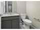 Clean half bathroom with a gray cabinet vanity and granite countertop at 6725 Mentha Dr, Castle Rock, CO 80108