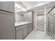 Elegant bathroom featuring double vanity, sleek gray cabinets, and a modern glass-enclosed shower at 6725 Mentha Dr, Castle Rock, CO 80108