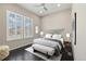 Comfortable bedroom with a ceiling fan, dark hardwood floors, and natural light from the shuttered windows at 6725 Mentha Dr, Castle Rock, CO 80108