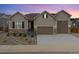 Beautiful home exterior featuring a manicured yard, stone accents, and a three-car garage at 6725 Mentha Dr, Castle Rock, CO 80108