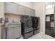 Laundry room featuring new washer and dryer units, sink, and storage cabinets at 6725 Mentha Dr, Castle Rock, CO 80108