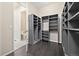 Spacious walk-in closet with custom shelving units and dark hardwood floors at 6725 Mentha Dr, Castle Rock, CO 80108