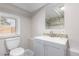 Well-lit bathroom featuring a modern vanity, stylish mirror, and pristine toilet at 1050 S Raleigh St, Denver, CO 80219