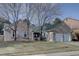 Charming brick home featuring a well-manicured front lawn, mature trees, and a two-car garage at 7006 S Miller Ct, Littleton, CO 80127