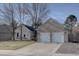 Charming brick home featuring a well-manicured front lawn, mature trees, and a two-car garage at 7006 S Miller Ct, Littleton, CO 80127