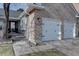 Close up of an attached garage highlighting the brick exterior and well-maintained landscaping at 7006 S Miller Ct, Littleton, CO 80127