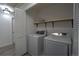 Convenient laundry room with modern washer and dryer units and storage shelving at 7006 S Miller Ct, Littleton, CO 80127
