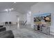 Open-concept living room with modern lighting, gray flooring, and a large flat-screen television at 7006 S Miller Ct, Littleton, CO 80127