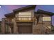 Beautiful modern home with wood and stone elements, a two car garage, and a deck at 5721 Country Club Dr, Larkspur, CO 80118