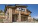 Stylish two-story house boasting stone accents, a deck, an attached two-car garage, and wood siding at 5721 Country Club Dr, Larkspur, CO 80118