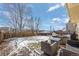 Spacious backyard with patio furniture and snowy ground at 4224 Deer Watch Dr, Castle Rock, CO 80104