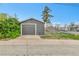 Exterior view of detached garage with gray siding, concrete driveway, and chain-link fence at 1000 S Perry St, Denver, CO 80219