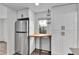 Kitchen with stainless steel refrigerator, white cabinets, and a small table with a window at 1000 S Perry St, Denver, CO 80219